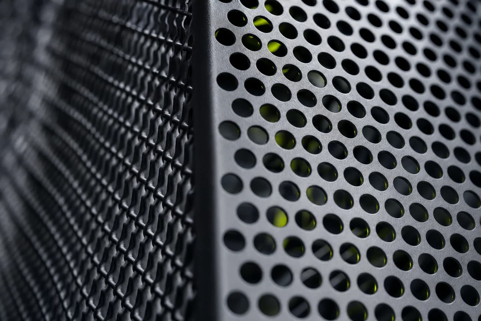 Close detail of perforated metal cooling infrastructure and dark steel mesh